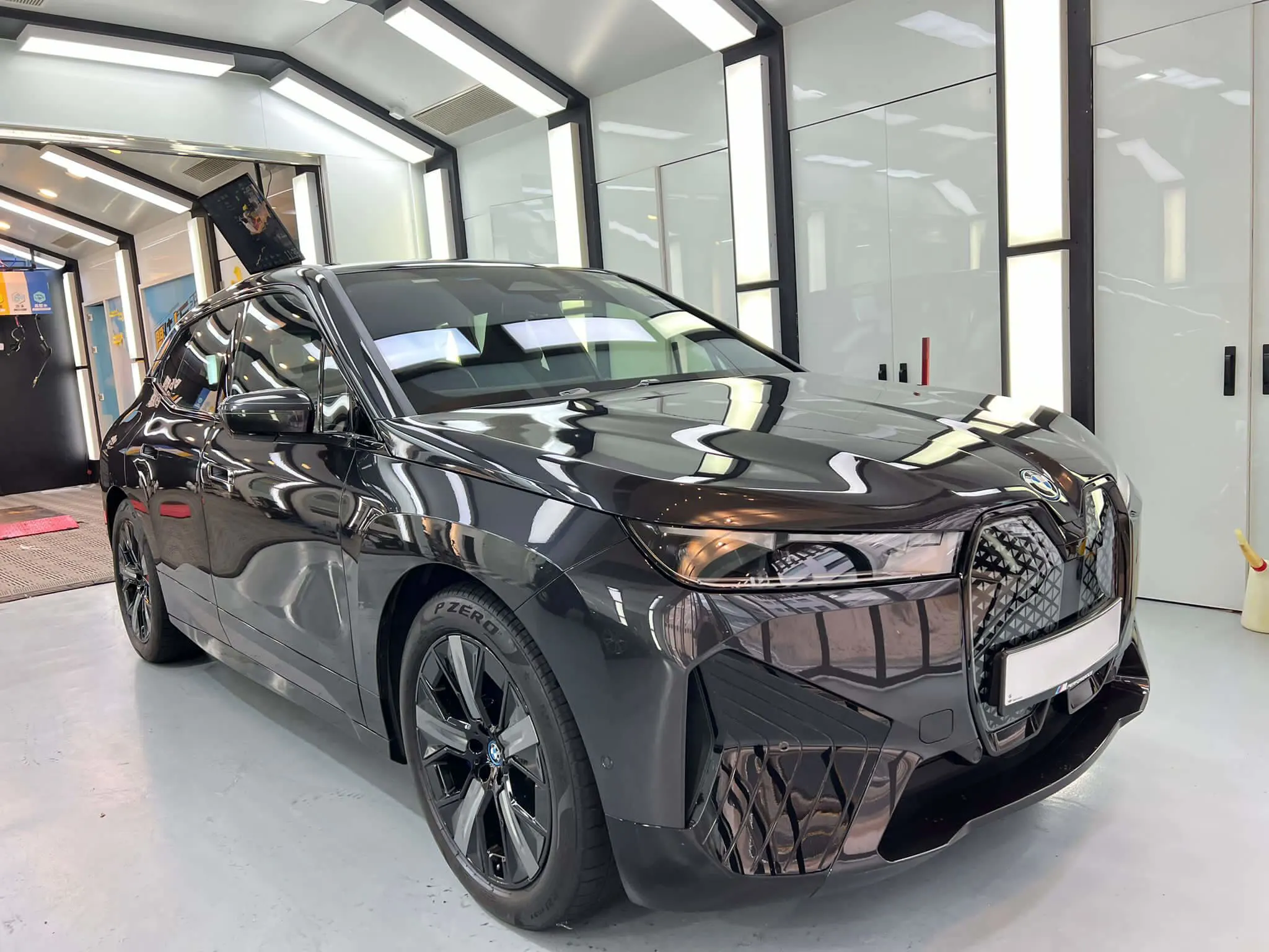 明亮汽车工场内的黑色 BMW iX