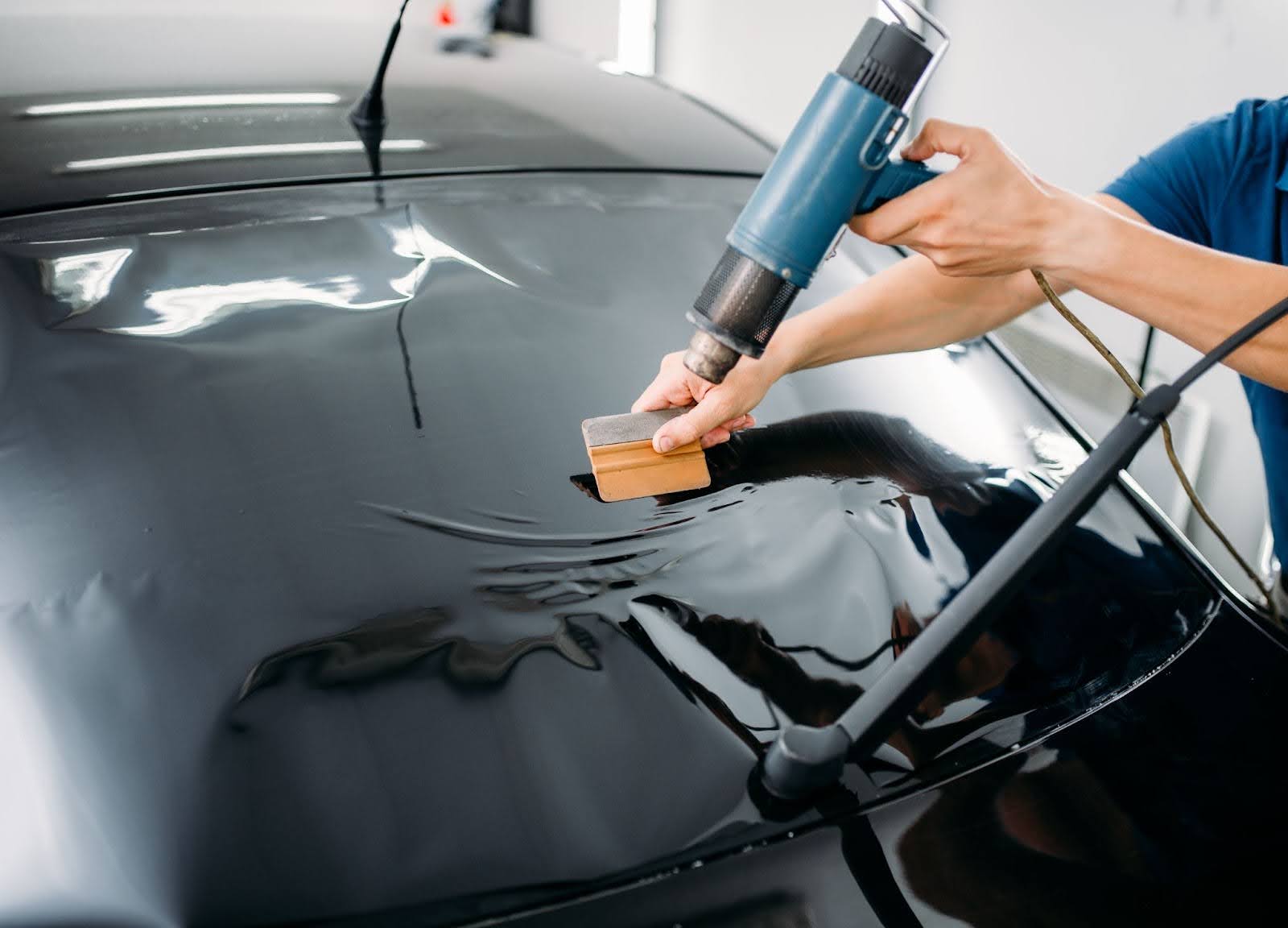 Technician heat-shaping film on a rear windscreen